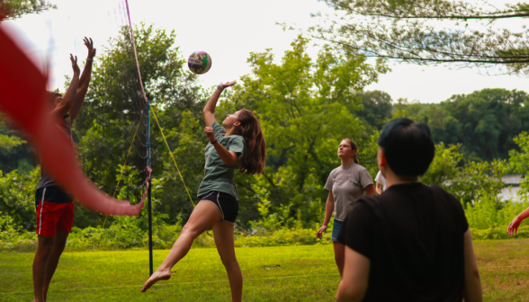 Students hits the ball over the net