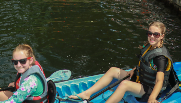 Two smile for the camera in their kayak