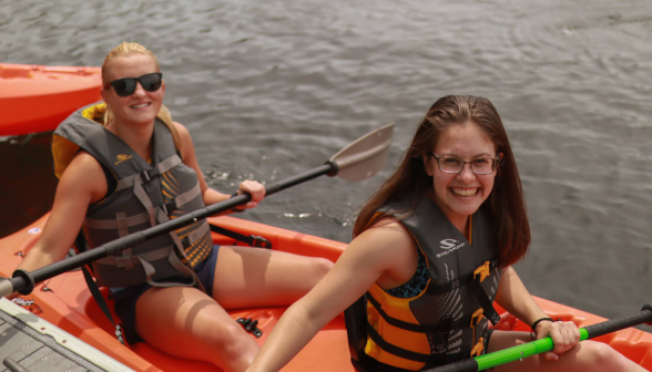 Two smile for the camera in their kayak