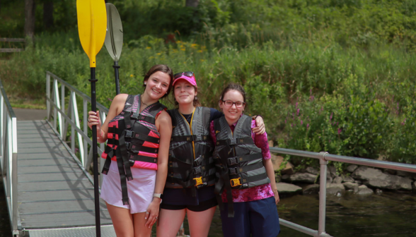 Three pose for a photo on the pier