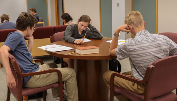 Three study around a table