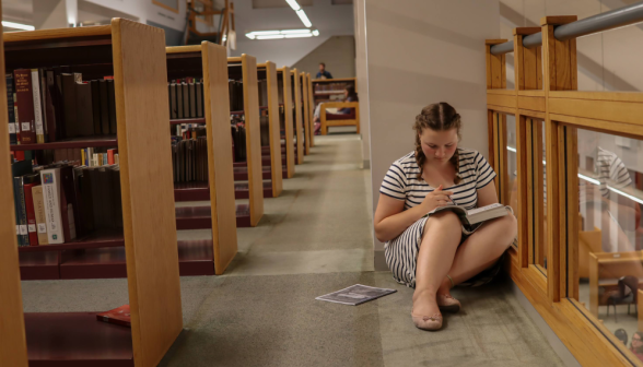 A student studies by the overlook down on the upper storey