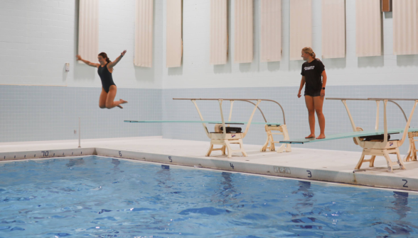 A student leaps off the diving board while another watches