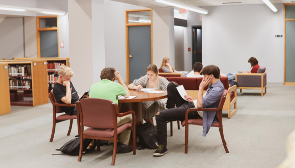 Four students study studiously around a table