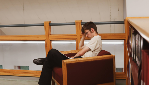 A student studies in an armchair