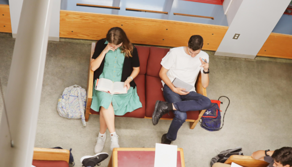 Two studying on a couch