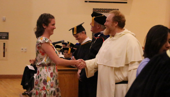 Fr. Michaels shakes hands with an incoming freshman
