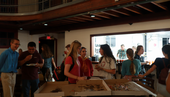 Students chat by the pizza