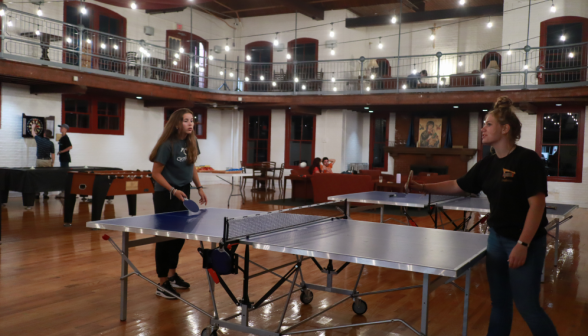 Two students play ping-pong