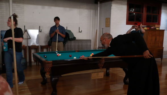 Fr. Viego plays pool with the students