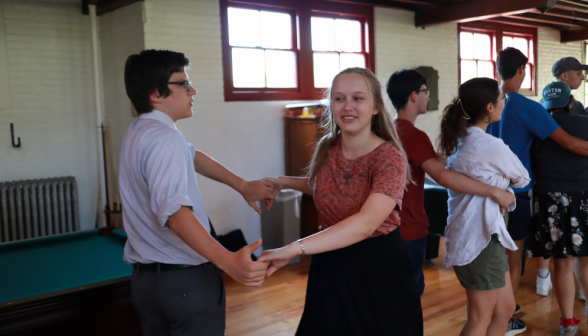 A row of student pairs practices their dance moves