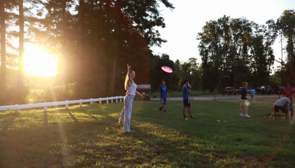 Students play Frisbee as the sun sets