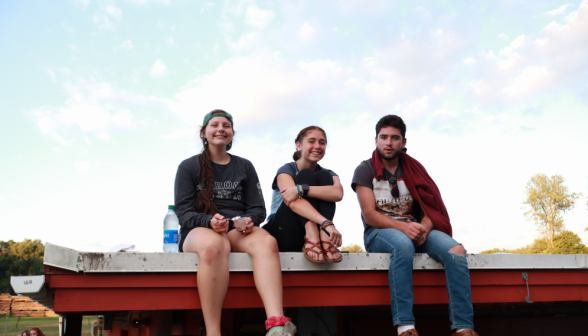 Three pose, seated atop the flat-roofed snack shop