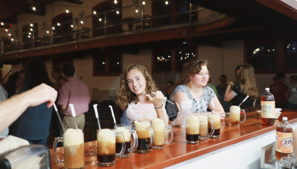 A prefect smiles for the camera by a row of root beer floats