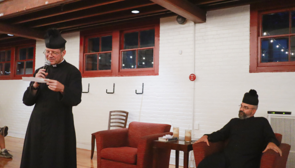 Fr. Markey reads out a question, while Fr. Viego watches from his armchair