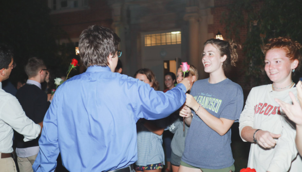 The men offer their flowers to the women