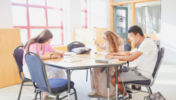 Three study at a hexagonal table