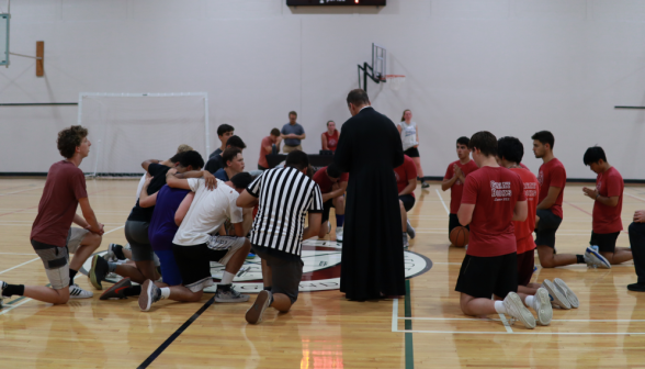 Fr. Markey leads the students in prayer pre-game