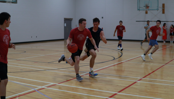 A student attempts to block a prefect advancing down the court