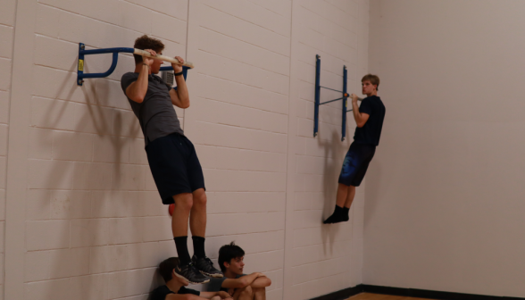 A pull-up contest to one side of the gym