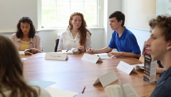 A student listens to another make a point about the text