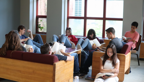 Eight study on couches and armchairs in one corner of the library