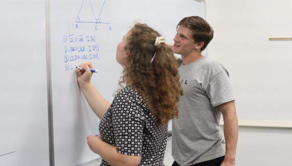 A prefect and a student discuss props at the board