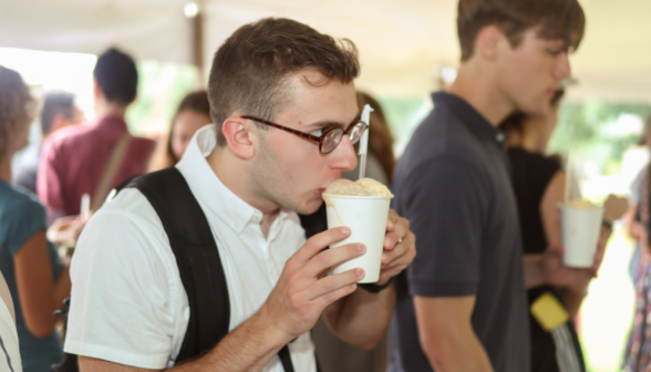 A student sips cautiously from a bubbling-over float