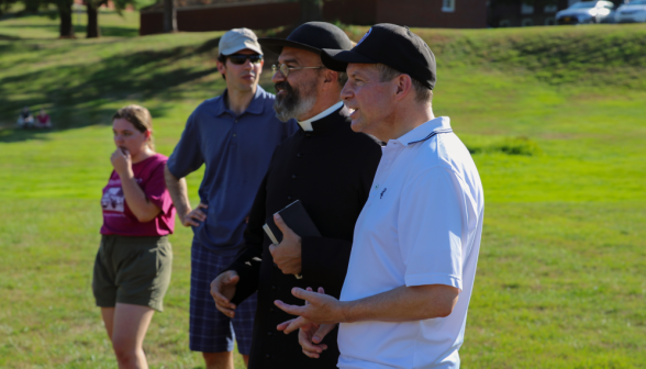 The chaplains, a tutor, and a student spectate the Tug of War