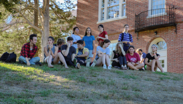 A group of students watching from the top of the rise