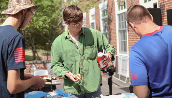 A student applies ketchup to his hotdog