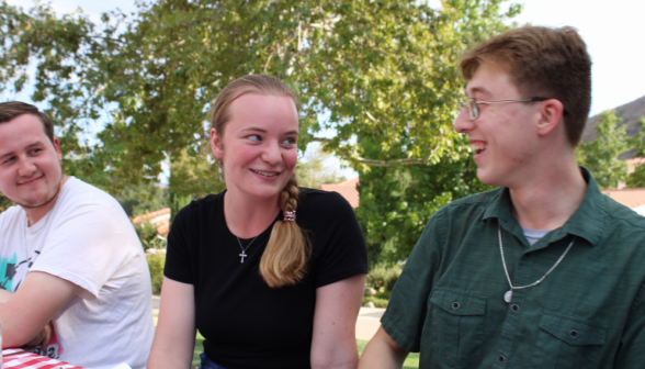 Three laugh and chat at the table