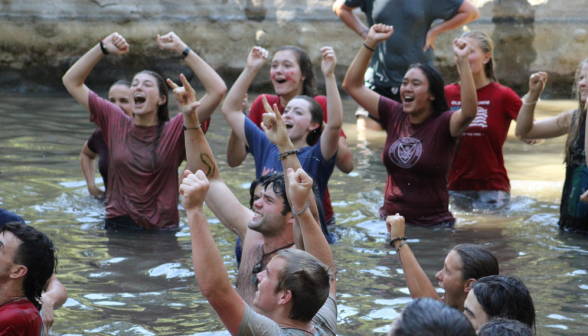 Enthusiastic cheering from a group of students in the pond, arms raised