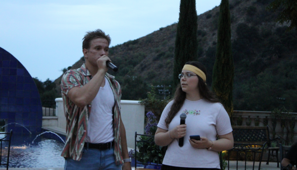 Two present their skit, microphones in hand