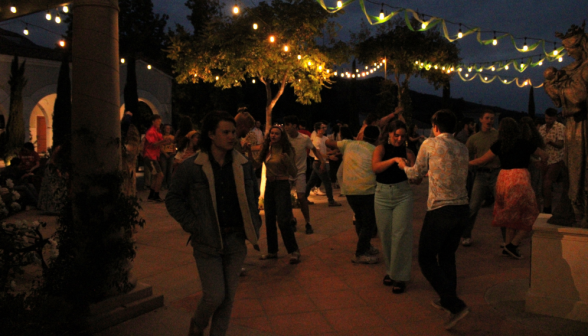 The students dance under the strings of hanging lights