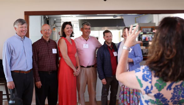 A group of visitors pose in Tracy for a photo