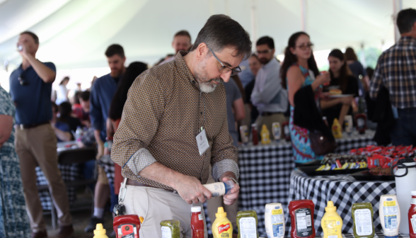 A visitor applies condiments to their hot dog
