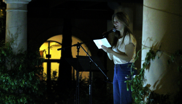 A student at the microphone with a sheet of paper in hand