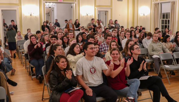 Students applaud and one gives a thumbs-up