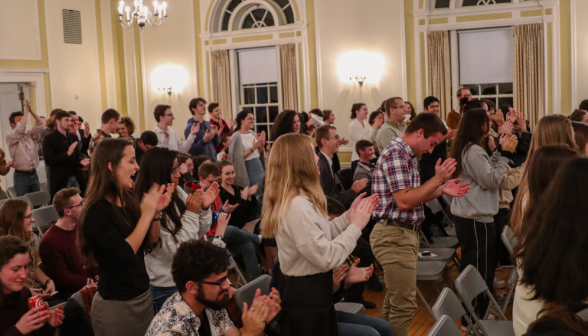 The other students also rise, applauding