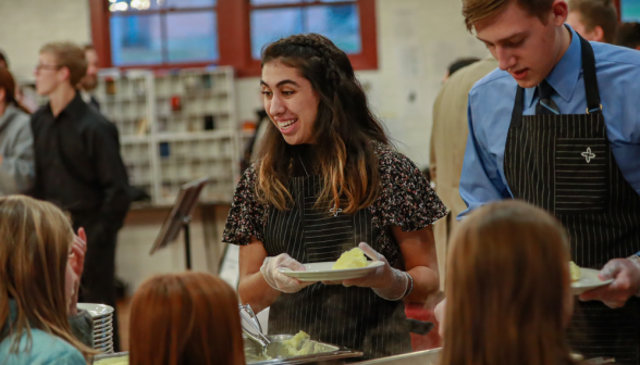 Two servers serve mashed potatoes