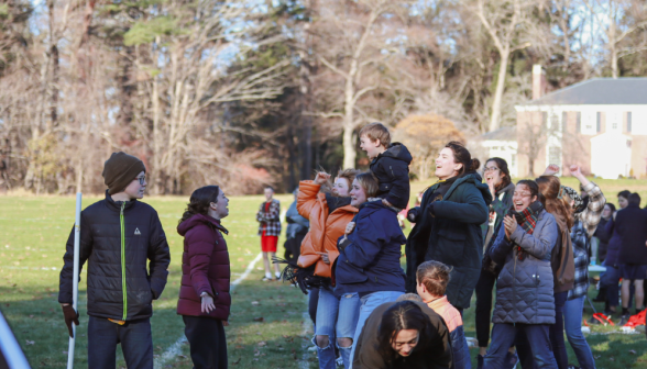 Students and tutor kids cheer on the sidelines