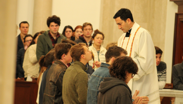 Fr. Lopez blesses students with the relic before finals