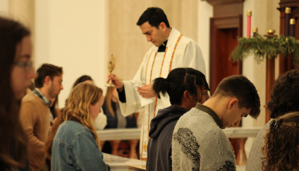 Fr. Lopez blesses students with the relic before finals