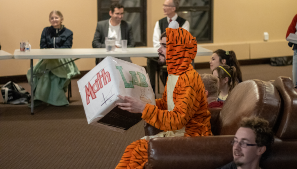The tiger-costumed student throws an enormous die