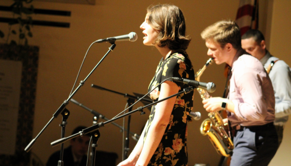 Singer, saxophonist, and a third student (obscured) perform
