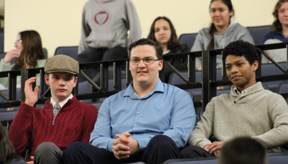 Three seated side by side in the auditorium