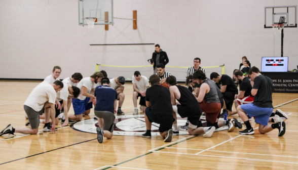 Students kneel to pray before the game