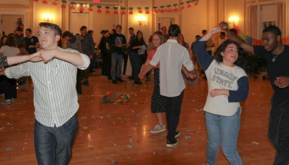 Students dance under strings of Mexican flags