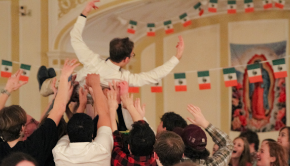 A student is lifted overhead on the arms of his comrades